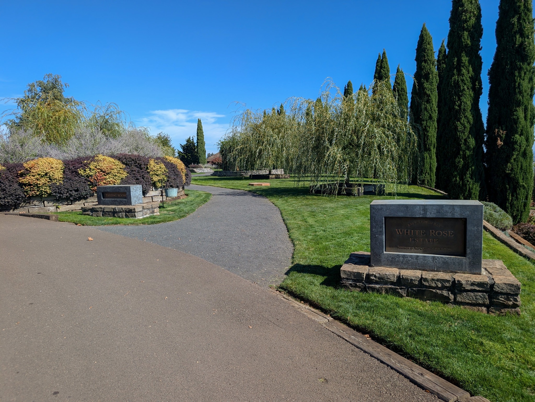 White Rose Estate entrance with landscaped gardens and tall narrow evergreen trees
